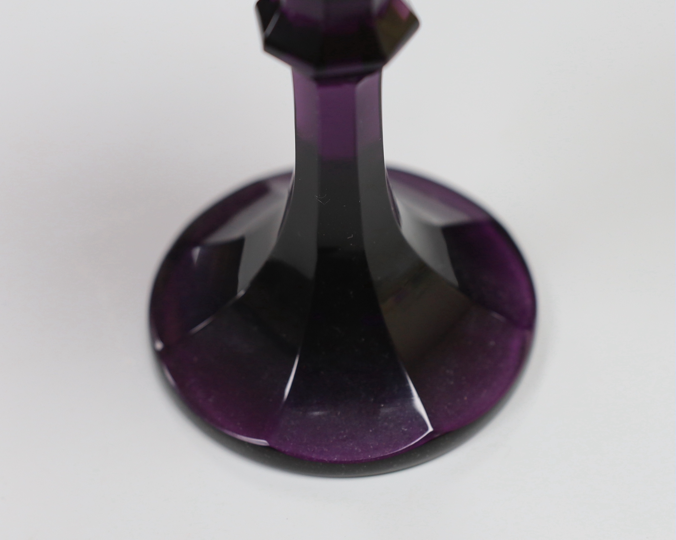 A Bohemian amethyst goblet, seemingly cut from a single piece of glass in a facetted form with a knopped stem cascading to a facetted foot with flat base and ground pontil, 17.5cm, weight 488 grams